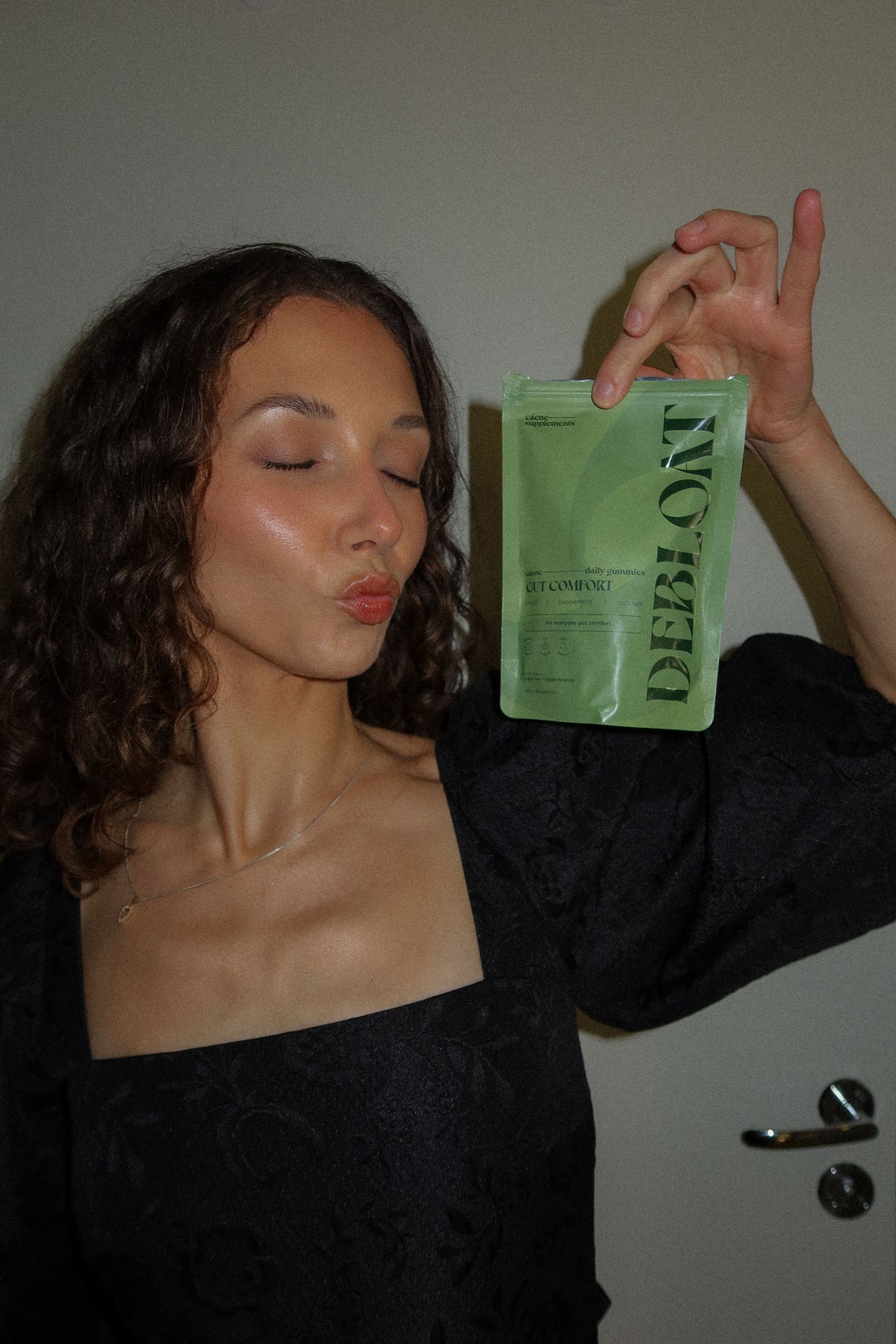 woman holding the green debloat pouch